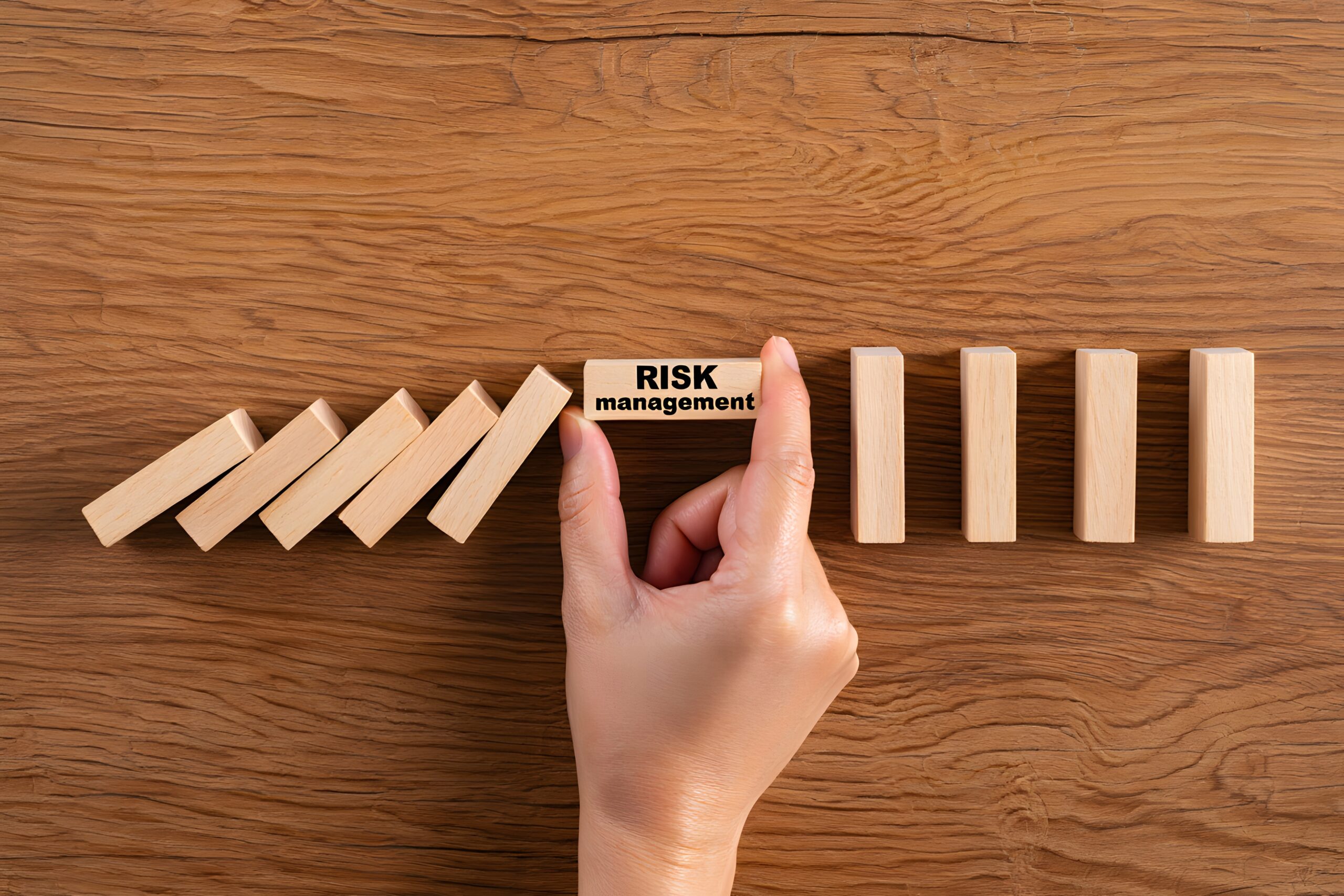 Hand Stopping Domino Effect with Risk Management Block